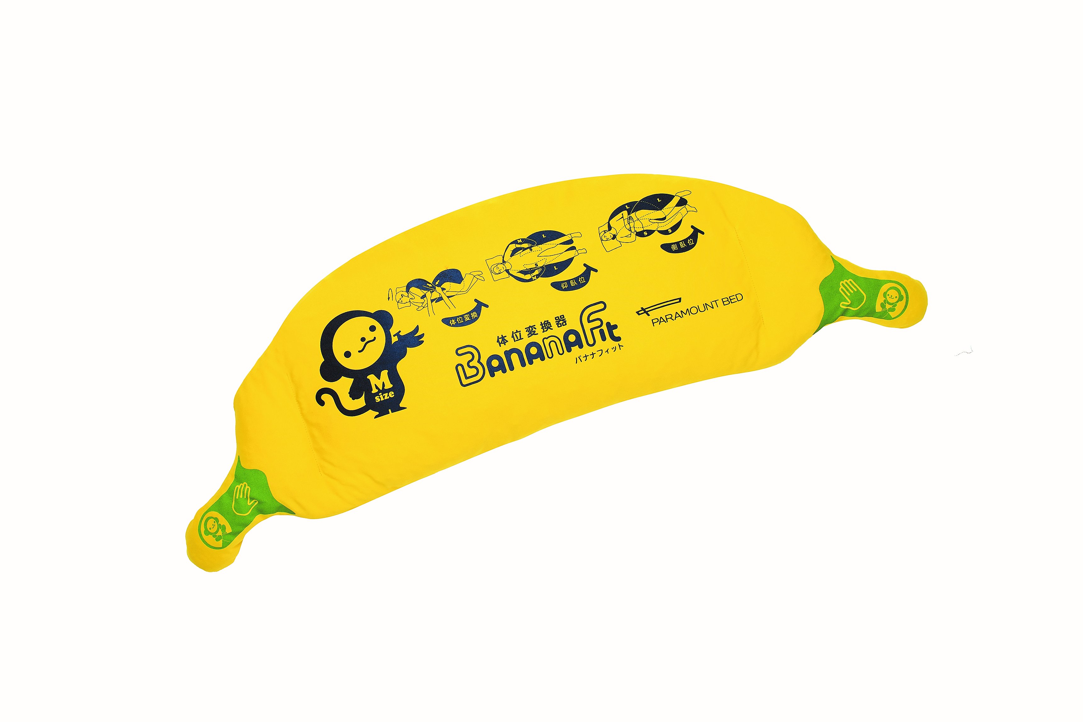 Pillow in yellow in the shape of a banana, with both ends compressed to form handles for grips. On the left of the pillow is the logo of a monkey with "M sizes" printed on it, followed by 3 samples of pictures showing how to position a person on the bed with this pillow. There are also the logo "Banana Fit" with its Japanese version of this word printed in the middle bottom of the pillow, with the company name "Paramount Bed" printed to its right.